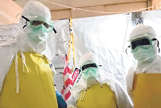 Jeff Deal, left, works with caregivers in Liberia to combat the spread of Ebola.