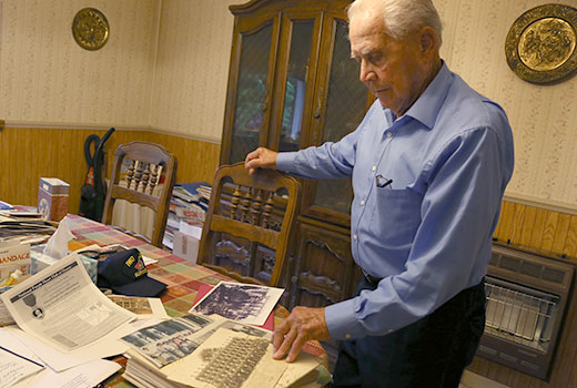 Horace Lee, 91, a Marine during World War II and Purple Heart recipient, looks over photos and newspaper clippings on the battle to wrest control of Iwo Jima from the Japanese. (Photo by Neisha Roberts)