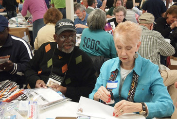 SCDC Chaplain Bernie Colclough and Irene Murphy check prisoner packets while adding Gospel tracts and other materials. The Christmas packets were delivered to every inmate in South Carolina the next day.