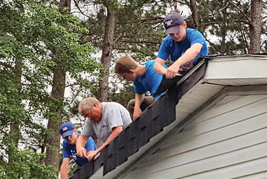 Student volunteers put a new roof on a house.