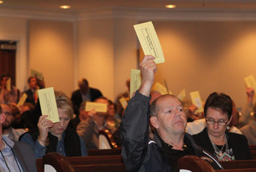 Messengers lift their ballots in favor of a motion.